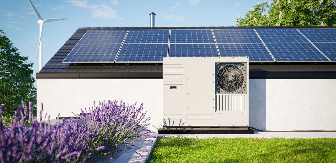 Auf dem Bild ist ein modernes Wohnhaus mit Solarmodulen auf dem Dach und einer Wärmepumpe an der Hauswand zu sehen. Lavendel und Rasen im Vordergrund sowie ein Windrad im Hintergrund stehen für nachhaltige und klimafreundliche Energieversorgung.