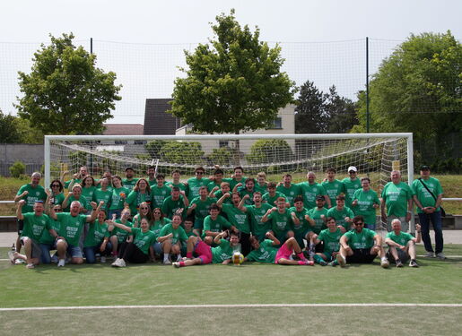 Zu sehen ist eine große Gruppe von Fußballspielern der Spielvereinigung Ingelheim. Die Spieler tragen alle ein grünes Trikot und haben sich auf dem Fußballplatz vor dem Tor platziert. Feudestrahlend lachen sie in die Kamera.