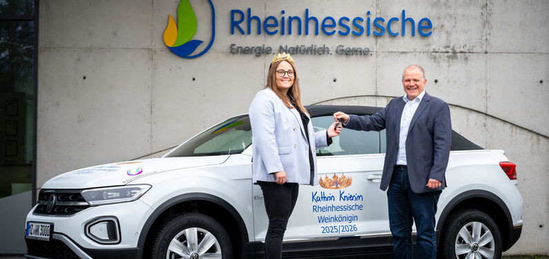 Das Bild zeigt die Weinkönigin Kathrin Knierim aus dem Jahr 2025, gemeinsam mit Martin Wunderlich, Geschäftsführer der Rheinhessischen, vor dem gesponserten Auto.