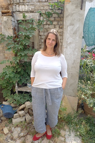 Miriam Maslowski stehend vor dem Bruchsteinmauerwerk
