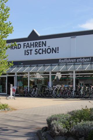 Aussenaufnahme der Firma Fahrrad Schön in Gau-Algesheim. Viele Fahrräder stehen draußen vor dem Gebäude.